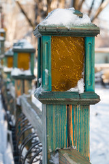 Snow-covered lanterns in a city park.