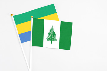 Norfolk Island and Gabon stick flags on white background. High quality fabric, miniature national...