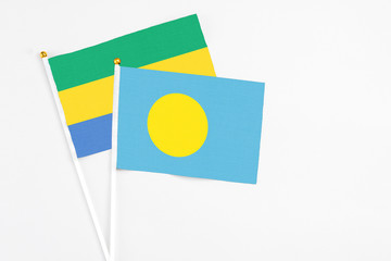 Palau and Gabon stick flags on white background. High quality fabric, miniature national flag....