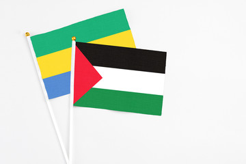 Palestine and Gabon stick flags on white background. High quality fabric, miniature national flag....