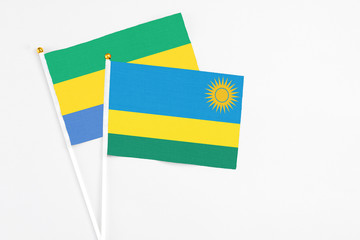 Rwanda and Gabon stick flags on white background. High quality fabric, miniature national flag....