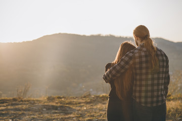 Love and valentines concept. Couple over natural background at the mountain looking in the Sunrise.