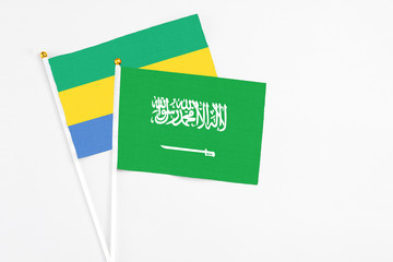 Saudi Arabia and Gabon stick flags on white background. High quality fabric, miniature national flag. Peaceful global concept.White floor for copy space.