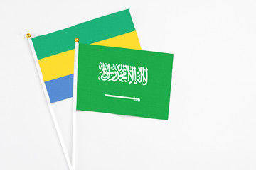 Saudi Arabia and Gabon stick flags on white background. High quality fabric, miniature national...