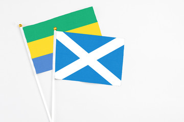 Scotland and Gabon stick flags on white background. High quality fabric, miniature national flag. Peaceful global concept.White floor for copy space.