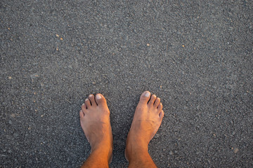 bare foot on Asphalt road