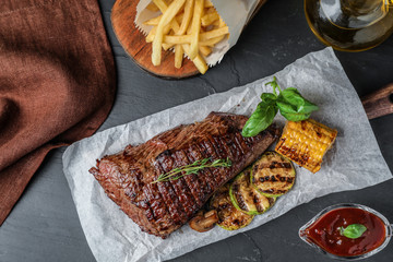 Delicious beef tenderloin served on grey table, flat lay