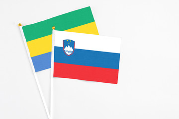Slovenia and Gabon stick flags on white background. High quality fabric, miniature national flag....