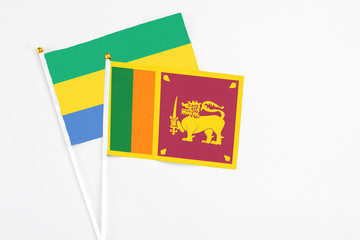 Sri Lanka and Gabon stick flags on white background. High quality fabric, miniature national flag....