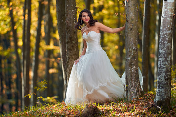 Bride in white dress in the forest