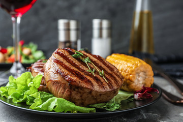 Delicious beef medallions served on grey table, closeup