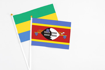 Swaziland and Gabon stick flags on white background. High quality fabric, miniature national flag....