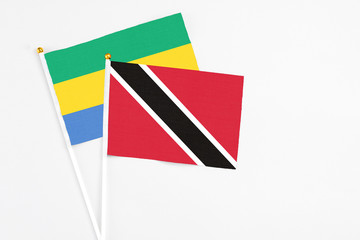 Trinidad And Tobago and Gabon stick flags on white background. High quality fabric, miniature...