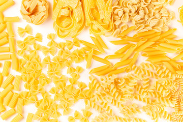 Italian pasta texture, flatlay banner, overhead shot on a white background. Fusilli, farfalle, penne, rigatoni and many other types