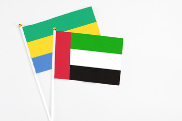 United Arab Emirates and Gabon stick flags on white background. High quality fabric, miniature...
