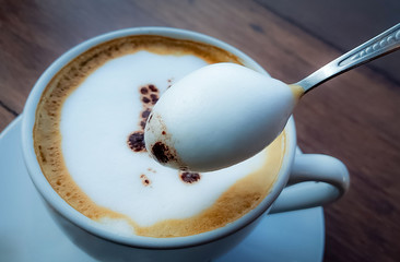 Blurred images of ready-to-drink cappuccino cups placed on a wooden table in the morning as background images and beautiful illustrations