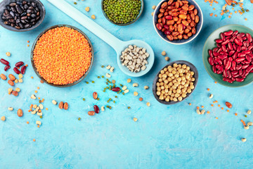 Legumes, shot from the top on a blue background with a place for text. Vibrant pulses including...