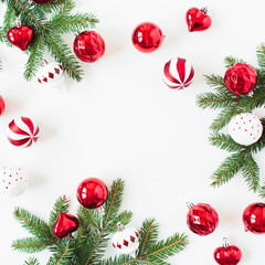 Christmas / New Year holiday composition. Mock up frame with blank copy space. Fir needle branches, Christmas baubles / balls, decorations on white background. Flat lay, top view festive concept.