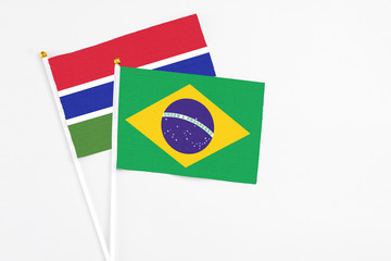 Brazil and Georgia stick flags on white background. High quality fabric, miniature national flag. Peaceful global concept.White floor for copy space.