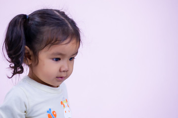 A little girl with a smiling face, two and a half years old, wearing a white shirt