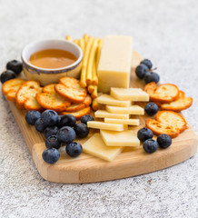 Crackers and cheese on wooden board