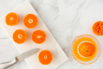 Cut Clementines on Marble Board and Citrus Juicer on Marble