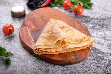 Delicious pancakes on wooden board, concrete gray stone table background. Top view homemade breakfast. Russian national food. Russian cuisine.