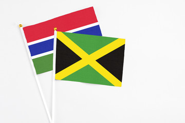 Jamaica and Georgia stick flags on white background. High quality fabric, miniature national flag. Peaceful global concept.White floor for copy space.