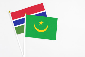 Mauritania and Georgia stick flags on white background. High quality fabric, miniature national flag. Peaceful global concept.White floor for copy space.