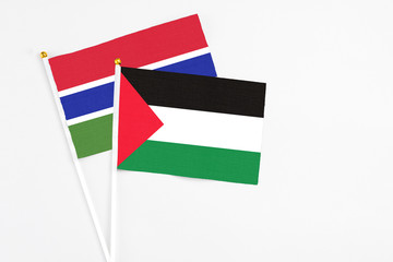 Palestine and Georgia stick flags on white background. High quality fabric, miniature national flag. Peaceful global concept.White floor for copy space.