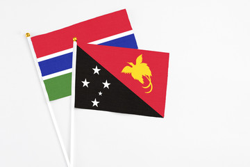 Papua New Guinea and Georgia stick flags on white background. High quality fabric, miniature national flag. Peaceful global concept.White floor for copy space.