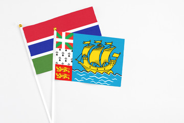 Saint Pierre And Miquelon and Georgia stick flags on white background. High quality fabric, miniature national flag. Peaceful global concept.White floor for copy space.