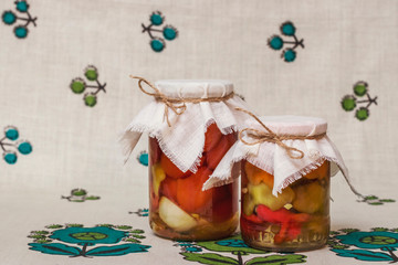 Two glass jars of canned vegetables on my grandmother's antique linen tablecloth. A vegetarian dish for the Christmas table. 