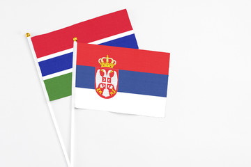 Serbia and Georgia stick flags on white background. High quality fabric, miniature national flag. Peaceful global concept.White floor for copy space.