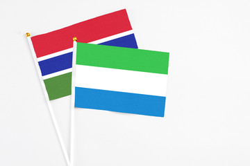 Sierra Leone and Georgia stick flags on white background. High quality fabric, miniature national flag. Peaceful global concept.White floor for copy space.