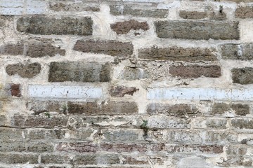 Old fortification wall from limestone. Restoration of a wall new blocks