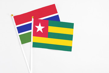 Togo and Georgia stick flags on white background. High quality fabric, miniature national flag. Peaceful global concept.White floor for copy space.