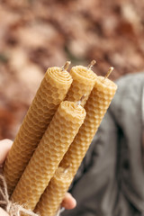 Handmade honey candles made from wax. Honey candles in the hands. The concept of unity with nature and relaxation.