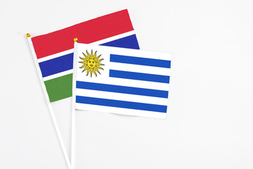 Uruguay and Georgia stick flags on white background. High quality fabric, miniature national flag. Peaceful global concept.White floor for copy space.