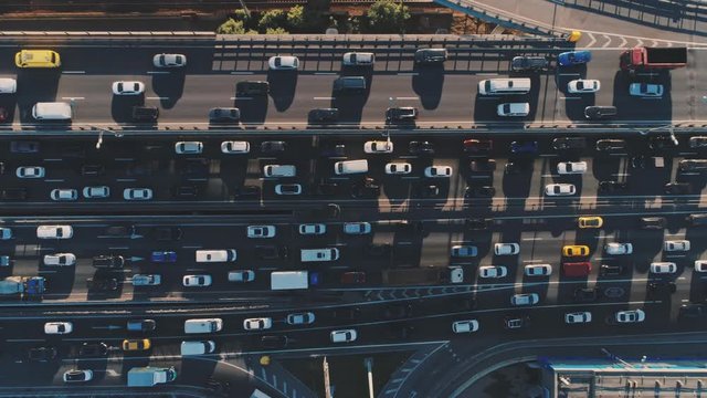 Aerial drone flight top view pan shot left to right of freeway busy traffic jam highway. Aerial view of the vehicular intersection, traffic at peak hour
