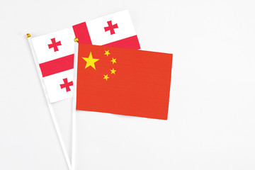 China and Georgia stick flags on white background. High quality fabric, miniature national flag. Peaceful global concept.White floor for copy space.