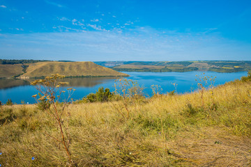 spring time grass land hills waterfront district of lake smooth waters nature reservation country side environment environment