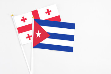 Cuba and Georgia stick flags on white background. High quality fabric, miniature national flag. Peaceful global concept.White floor for copy space.