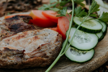 meat with bone on a grill with vegetables