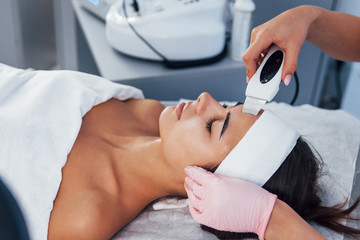 Using special device. Close up view of woman that lying down in spa salon and have face cleaning procedure