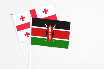 Kenya and Georgia stick flags on white background. High quality fabric, miniature national flag. Peaceful global concept.White floor for copy space.