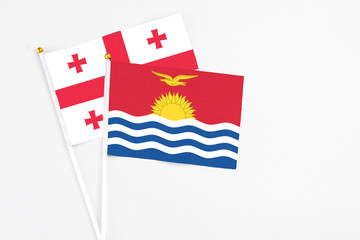 Kiribati and Georgia stick flags on white background. High quality fabric, miniature national flag. Peaceful global concept.White floor for copy space.