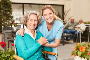 Glückliche Senior Frau und Pflegehilfe