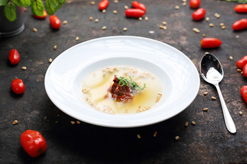 Consome, aromatic transparent tomato soup with the addition of dried tomatoes and roasted pine nuts.