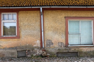 Wooden wall of a house with crumbled plaster